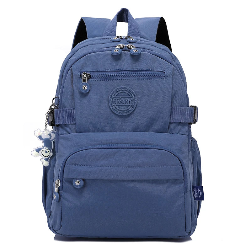 Sac de voyage robuste bleu marine avec plusieurs compartiments et un écusson logo circulaire.