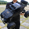 A black high-speed 4WD off-road RC truck with large tires and a roll cage is shown outdoors.