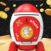 A red and white rocket shaped piggy bank with a key lock is shown on a sandy surface surrounded by gold coins.