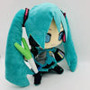 A teal plush doll of Hatsune Miku with long hair and black outfit holding a white pencil.