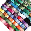 A collection of vibrant embroidery thread skeins in various shades of green, blue, pink, and yellow.