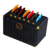 A black guitar pick holder with slots filled with various colored picks.
