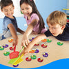 Three children are playing with a colorful fly swatter game set on a wooden table.