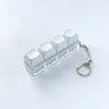 Clear acrylic fidget keychain with four white clicky key buttons attached to a silver chain.