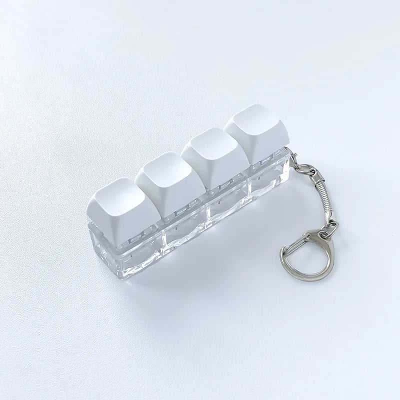 Clear acrylic fidget keychain with four white clicky key buttons attached to a silver chain.