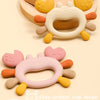 A silicone crab teether in yellow and white is shown with a cute cartoon crab design for a baby's teething.