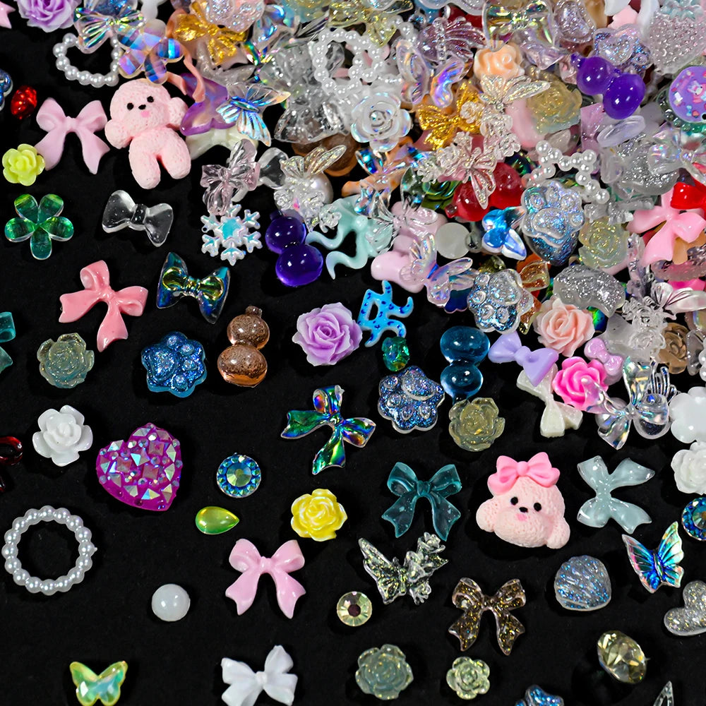 A mix of multicolor aurora resin nail charms including flowers, hearts, and various shapes.
