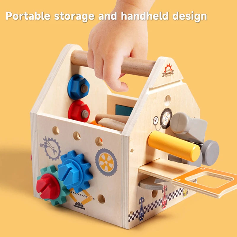 A wooden busy house toolbox with various gears, levers, and a screwdriver component is shown being held by a hand.
