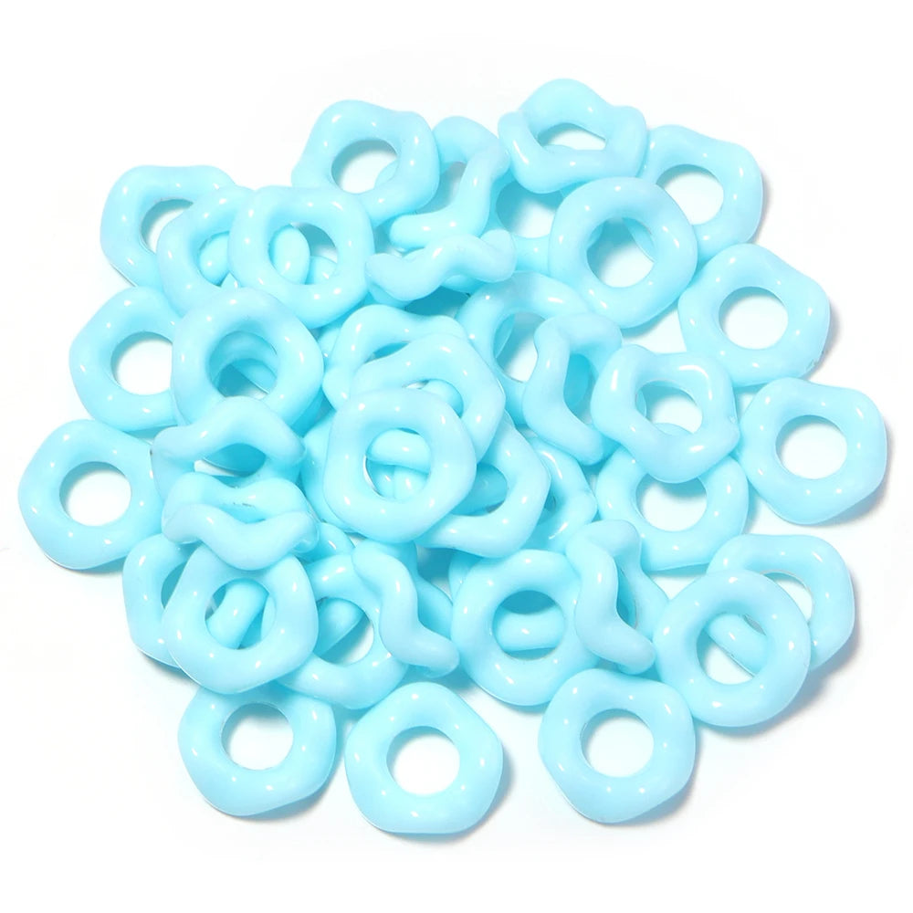 A pile of light blue acrylic doughnut spacer beads for jewelry making