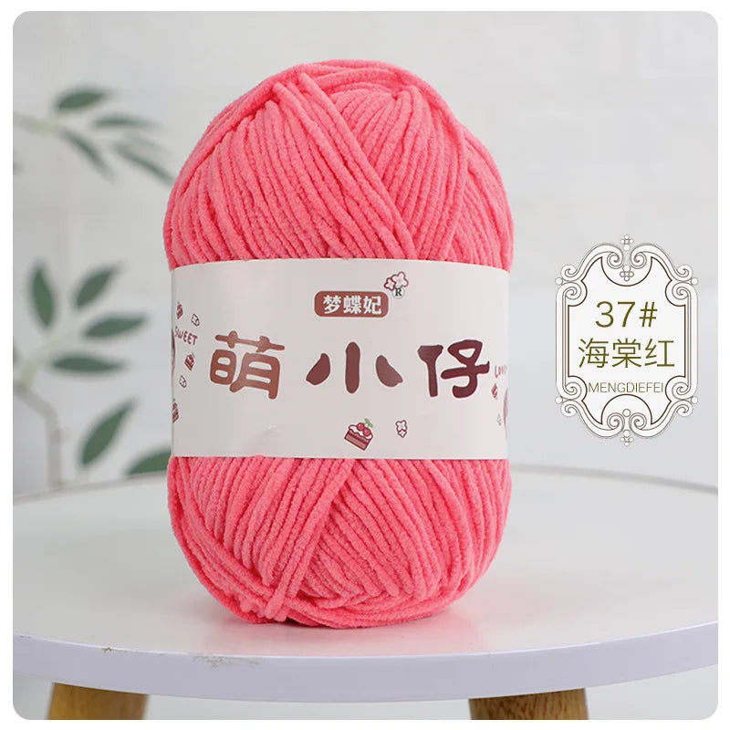 A ball of bright pink chenille yarn labeled with Chinese characters for knitting and crochet.