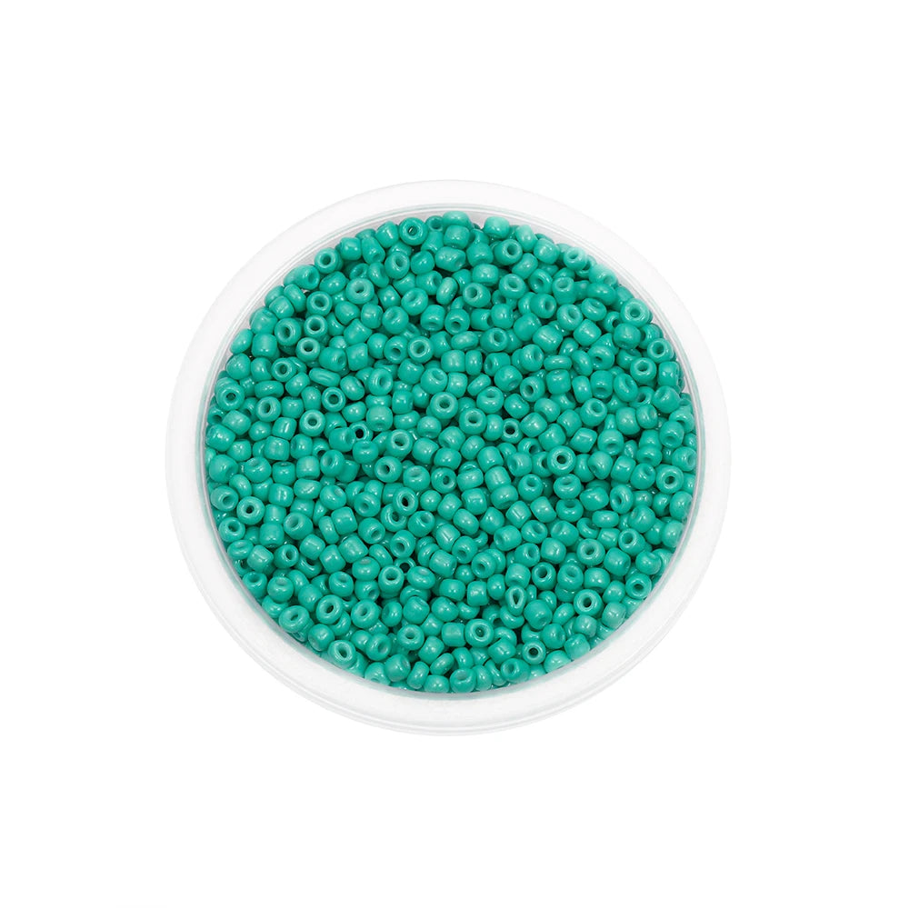 A clear container filled with small, round, teal glass seed beads for jewelry making.