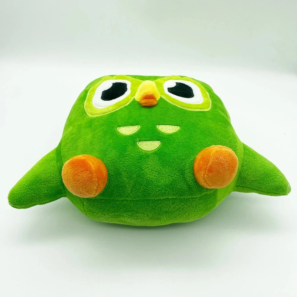 A soft green plush toy of Duo the Owl with large eyes and an orange beak.