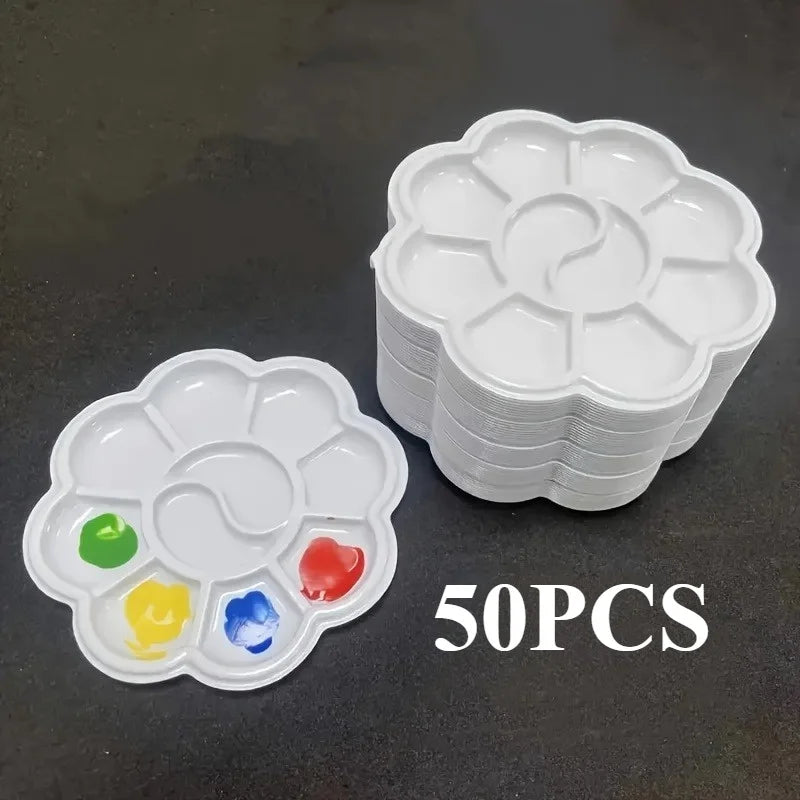 A stack of white flower-shaped disposable paint palettes with colored paint wells on a dark surface.