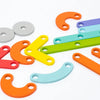 A collection of colorful wooden Montessori pegboard puzzle pieces in various shapes and sizes.