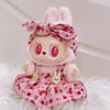 A fluffy pink bunny doll wearing a floral dress and bow, with strawberry themed accessories.