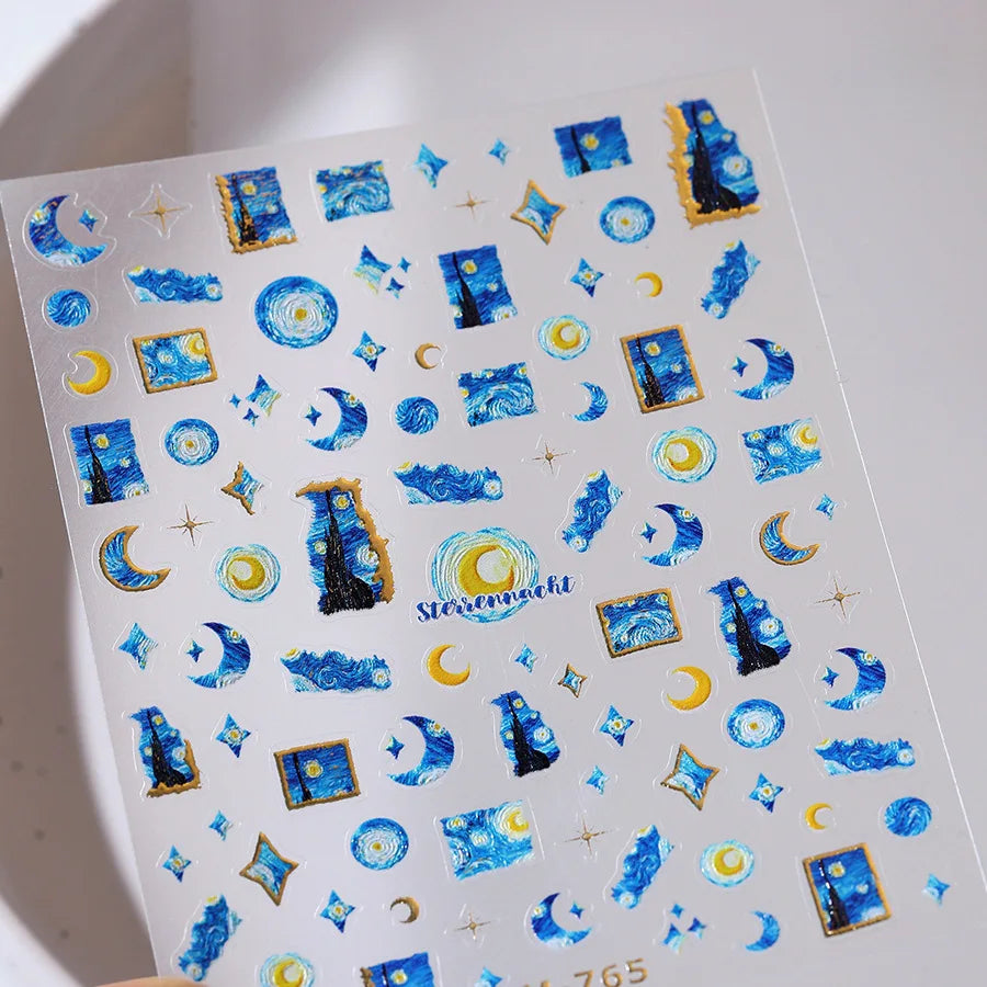 Sheet of blue and gold nail art stickers featuring moons, stars, and abstract designs