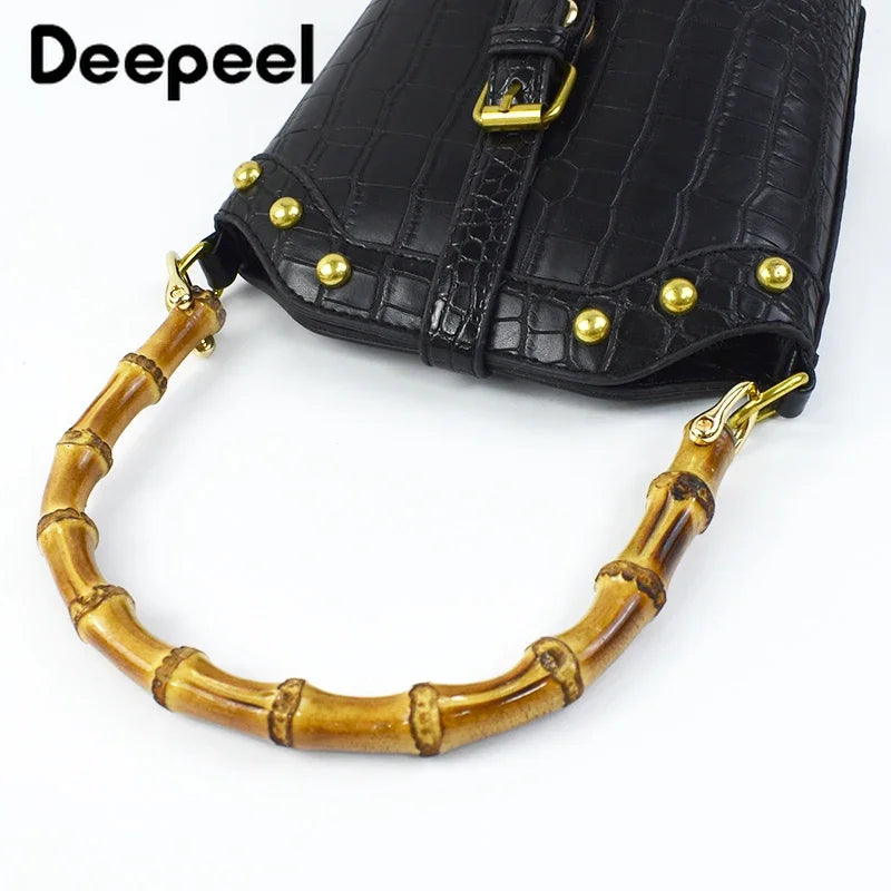 Black faux leather purse with gold hardware and bamboo-style handles