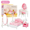 A pink miniature dollhouse furniture set featuring a vanity mirror, a bed, and various playset items.