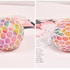 A close-up of a rainbow squishy stress relief ball with multicolored, soft, textured surface.