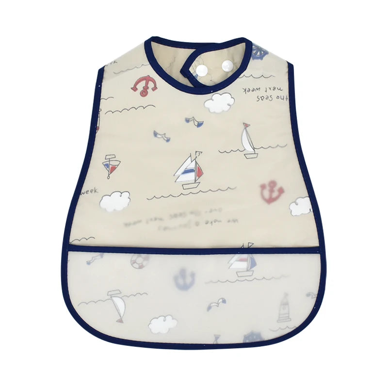 A cream-colored waterproof baby bib with a cartoon sea theme featuring anchors, sailboats, and clouds.