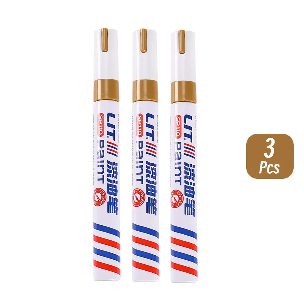 Three permanent paint markers in white and blue with gold accents for rubber, fabric, and metal.