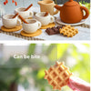 A silicone tea set featuring a teapot, cups, and food playset items like chocolate and waffle cookies.