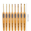 An arrangement of eight wooden crochet hooks with varying sizes ranging from 4/0 to 10/0 in gold and natural wood tones.