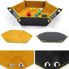 A hexagonal folding PU leather dice tray in yellow and black with colored dice inside.