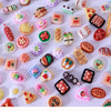 A collection of colorful miniature dollhouse snack foods including candies, jellies, and pastries arranged on a white surface