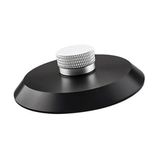 A round, silver aluminum alloy record stabilizer with a textured surface sits on a black base.