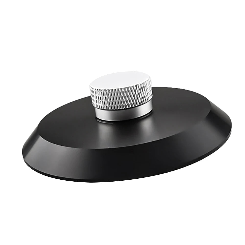 A round, silver aluminum alloy record stabilizer with a textured surface sits on a black base.