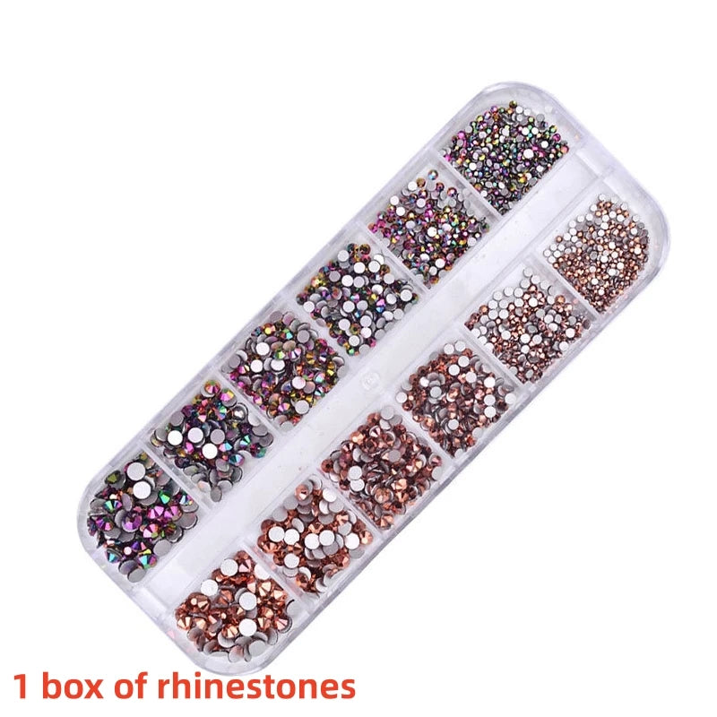 A box containing various colored rhinestones and glass gems for nail art decoration.