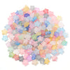 A pile of colorful transparent star acrylic beads in shades of pink, blue, yellow, and purple for jewelry making