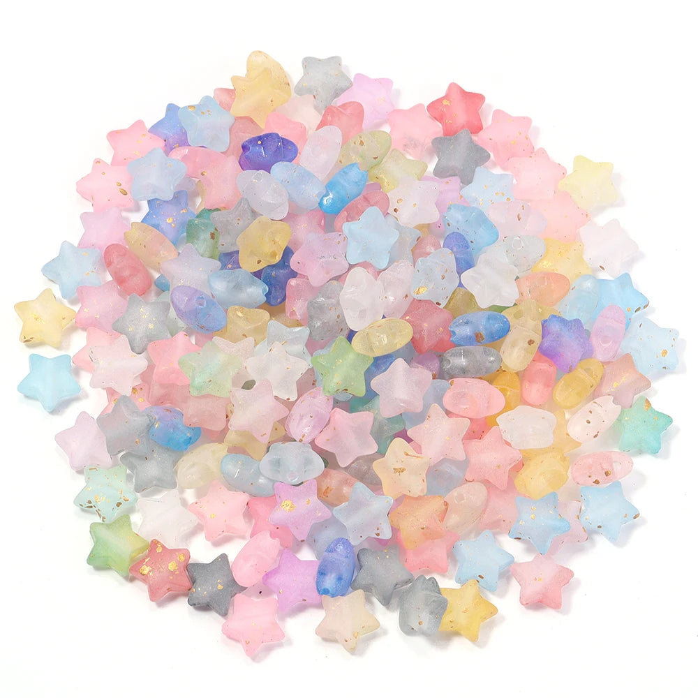 A pile of colorful transparent star acrylic beads in shades of pink, blue, yellow, and purple for jewelry making