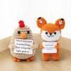 Handmade crochet fox doll with orange and white fur and a sign that says There is a crack in everything that's how the light 