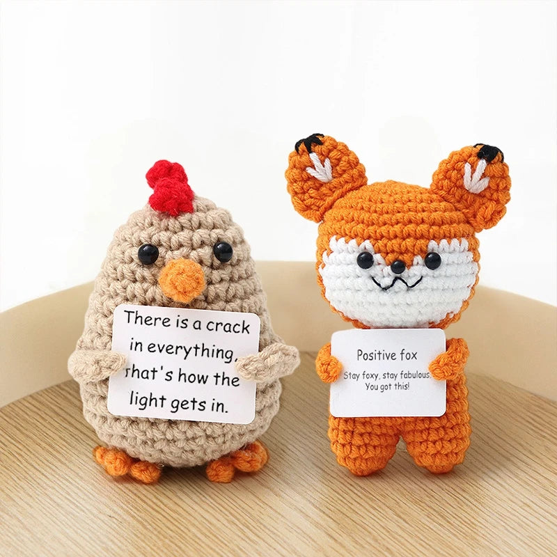 Handmade crochet fox doll with orange and white fur and a sign that says There is a crack in everything that's how the light 