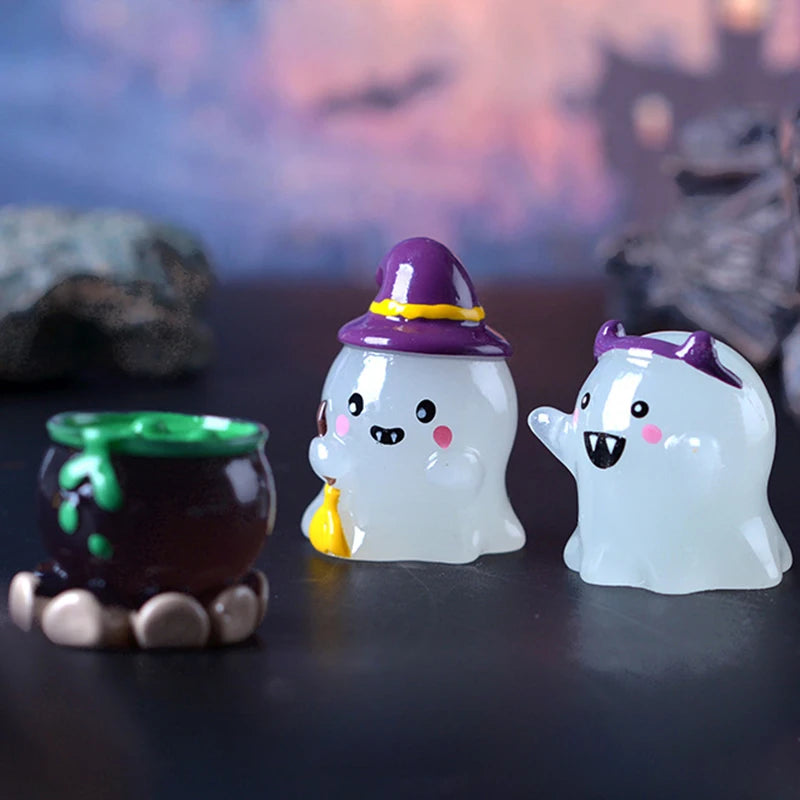 Adorno de calabaza fantasma de vidrio blanco con sombrero de bruja morado y detalles amarillos sobre una superficie oscura.