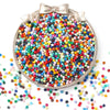 A circular display of 100 rainbow pony beads in various colors scattered on a white surface.
