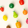 A collection of wooden magnetic fruit shapes including a watermelon, pumpkin, and lime in various colors.