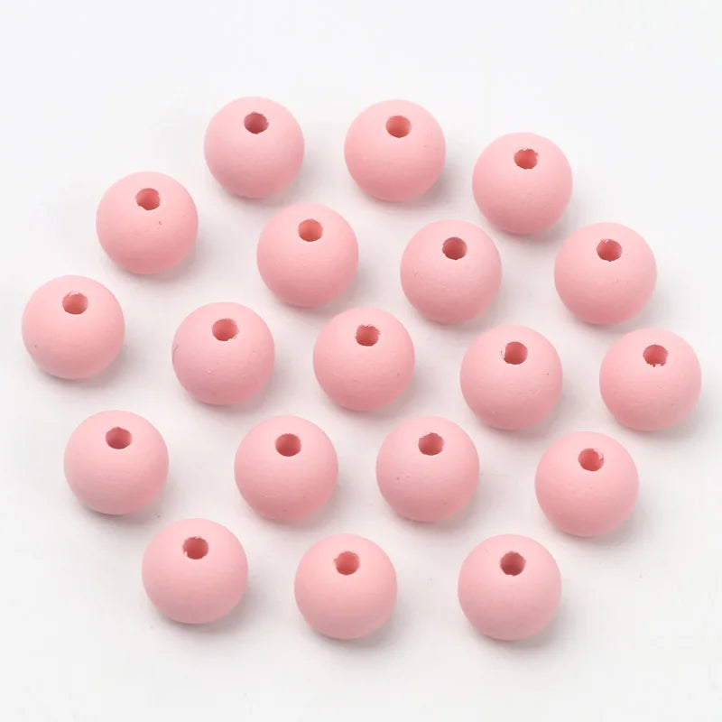 A collection of pink matte acrylic beads shaped like macarons for jewelry making