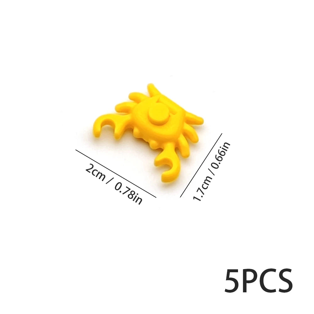 Five yellow plastic marine creature building blocks shown against a white background.