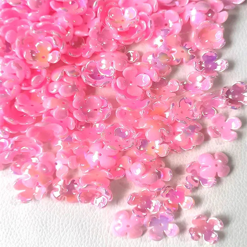 A close-up of pink and purple acrylic flower beads used for jewelry making.