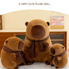 Three brown plush dolls resembling bears wearing knit scarves sitting on a white surface.