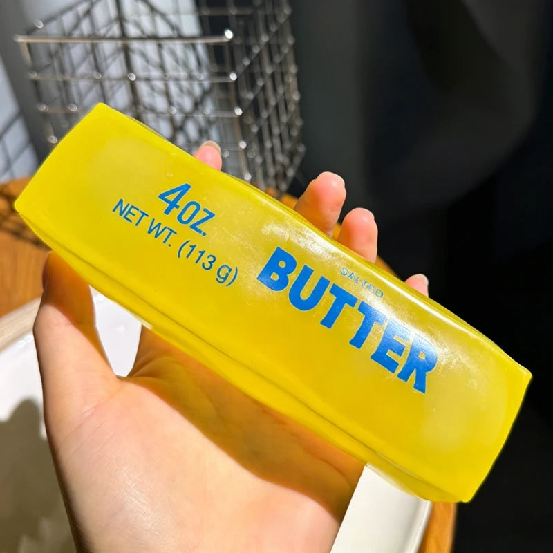 A hand holds a yellow squeeze bottle labeled Butter with 4 oz net weight.