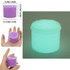 A clear plastic container of glow-in-the-dark crystal slime in a bright cyan color, shown next to a hand for scale.