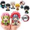 A set of Demon Slayer characters including Tanjiro and Nezuko figures displayed on a hand.
