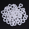 A pile of white acrylic doughnut spacer beads for jewelry making