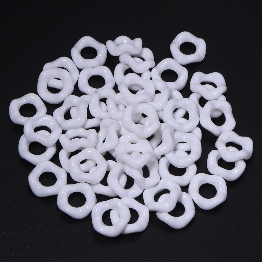 A pile of white acrylic doughnut spacer beads for jewelry making