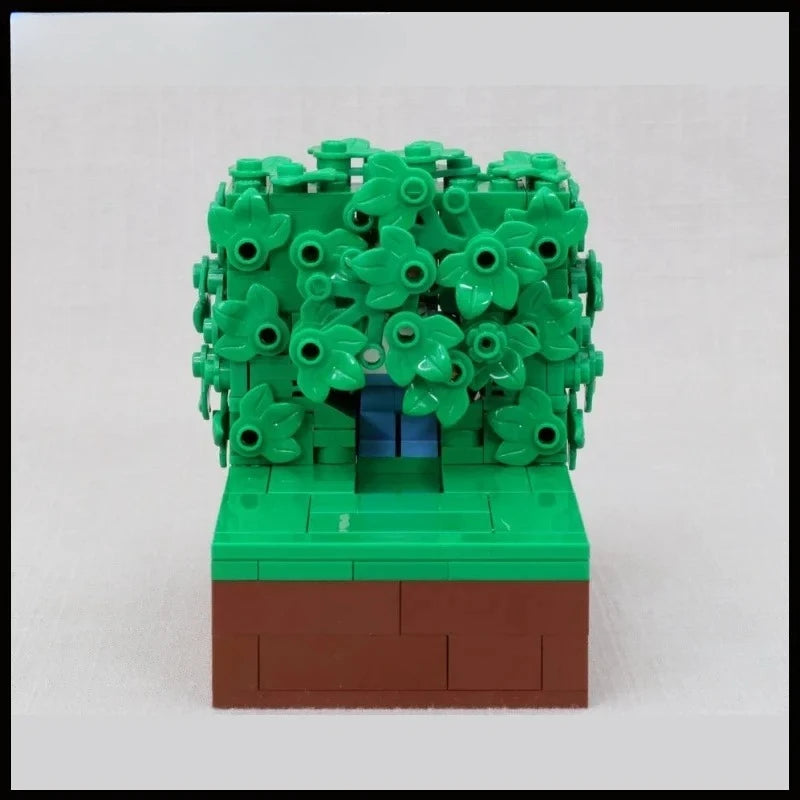 A LEGO building block model of Homer in the bushes scene featuring green foliage and a brown base.