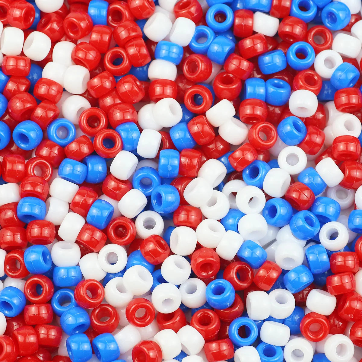 A close-up view of small, colorful pony beads in various shades of red, white, and blue.